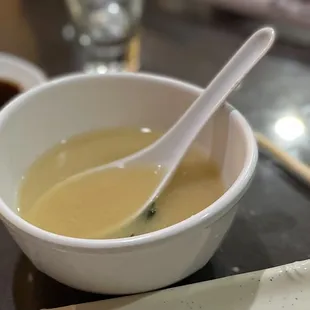 a bowl of soup and chopsticks on a table