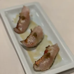 three pieces of sushi on a white plate