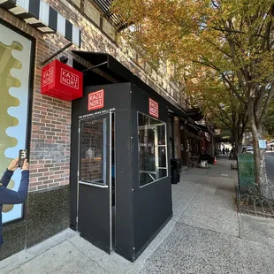 a woman taking a picture of a storefront