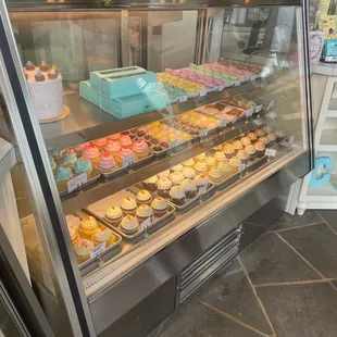 a display case filled with cupcakes