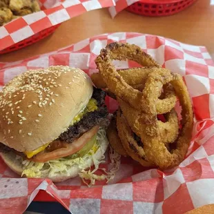 Cheeseburger with lettuce, tomatoes, and onion rings