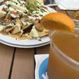 a plate of nachos and a drink