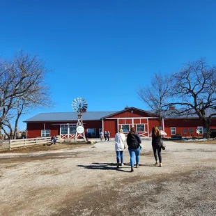 a group of people standing in front of a red barn