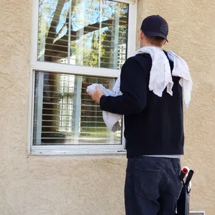David, the owner, cleaning a client's window