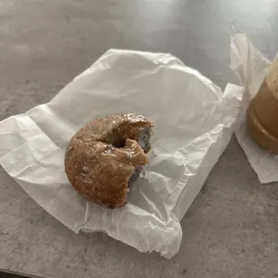 a half eaten doughnut and a cup of coffee