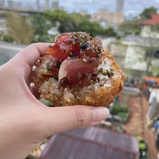 a hand holding a piece of food