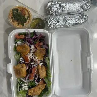 Greek salad with chicken and a side of hummus with bread
