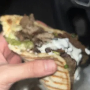 a hand holding a sandwich