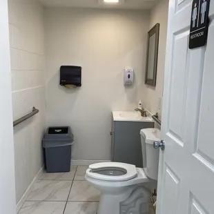 a bathroom with a toilet and trash can