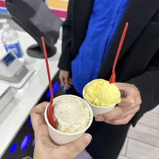 a man holding two bowls of ice cream