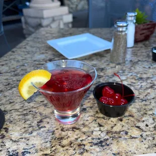 Cosmopolitan martini with cherries on the side.
