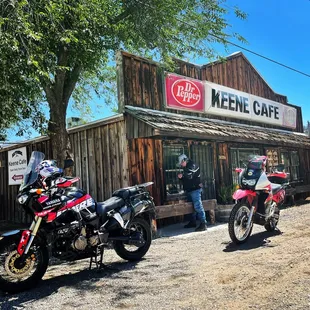 two motorcycles parked in front of a cafe