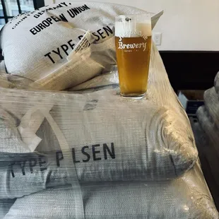 a pint of beer sitting on a stack of bags
