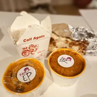 two bowls of soup and naan bread