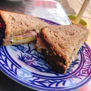 a sandwich cut in half on a blue and white plate