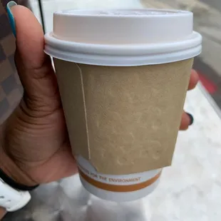 a hand holding a coffee cup