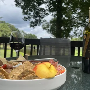 Small charcuterie platter with a bottler of Negro Amaro wine on the tasting room deck.