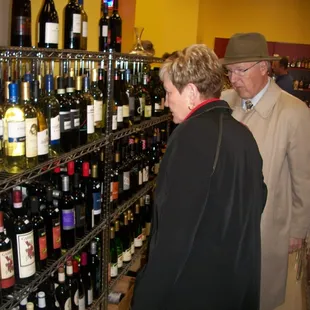 two people looking at bottles of wine