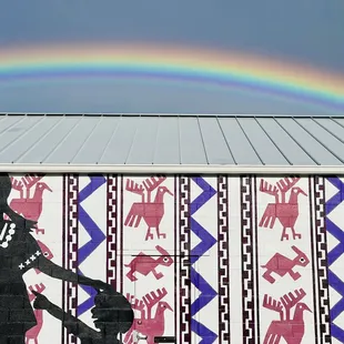 A client recently sent us these amazing photos of a rainbow glowing behind our building. We love it!