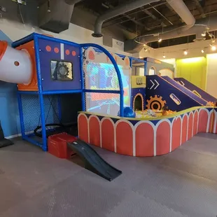 Side view of huge ball pit, game screen, and slide.