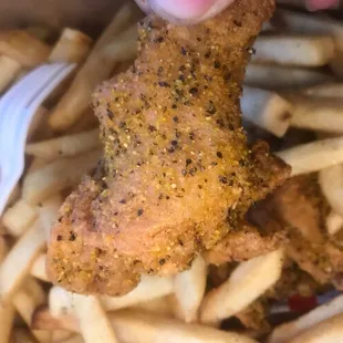 Lemon Pepper Wing in a sea of fries.