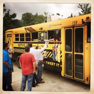 a group of people standing in front of a food truck