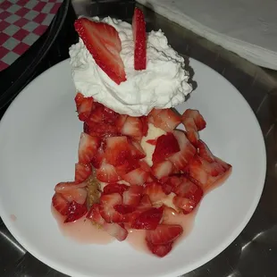 a strawberry pie with whipped cream and strawberries