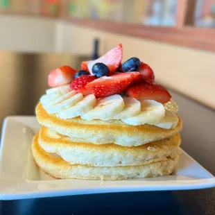 a stack of pancakes topped with fresh fruit