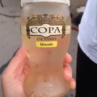 a person holding a cup of cold water