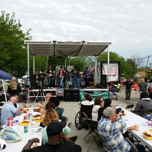 a large group of people sitting at picnic tables
