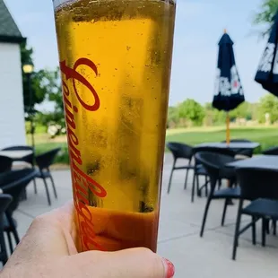 a person holding a glass of beer