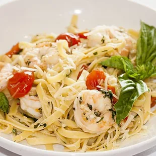 a plate of pasta with shrimp and tomatoes