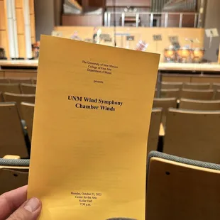 a hand holding up a yellow sheet of paper