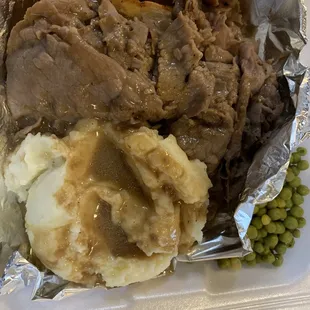 a meal of meat, mashed potatoes and peas