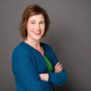 Professional studio headshot with grey background