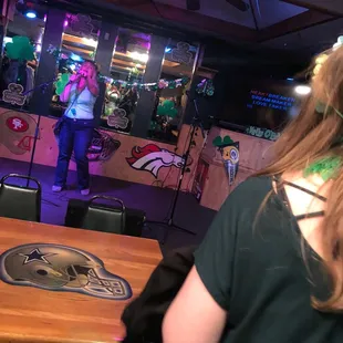 a woman singing in a sports bar