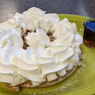 Waffle with butter, powdered sugar, and whipped cream