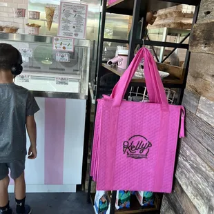 a little boy looking at a pink bag