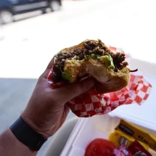 a hand holding a sandwich