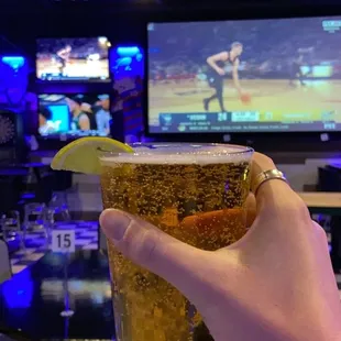 a person holding a glass of beer