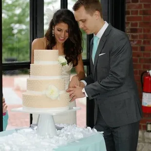 a bride and groom cutting the cake