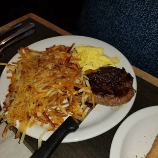 Breakfast steak, eggs, and hashbrowns, and toast.