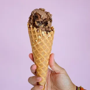 a hand holding an ice cream cone