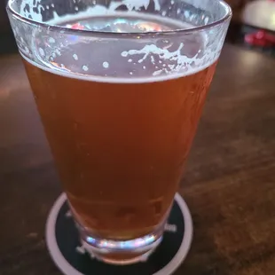 a glass of beer on a coaster