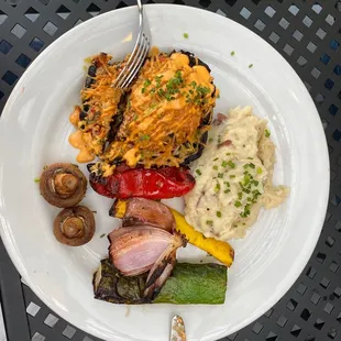 Pesto stuffed Portabella with vegetables and mashed potatoes.