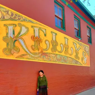 a woman leaning against a wall