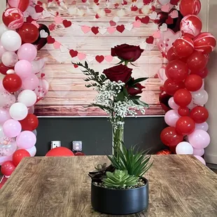a vase of flowers and balloons