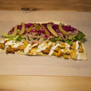 Succulent marinated chicken, slow-roasted to perfection, wrapped in warm pita with garlic sauce, creating an irresistible Middle Eastern del