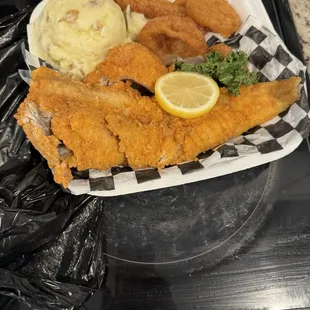 White fish, mashed potatoes and onion rings.