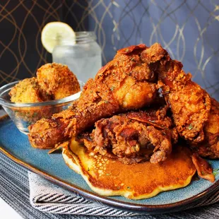Famous Fried Chicken &amp; Pancakes topped with (optional) crispy bacon crumbles and house-made syrup served with Panko potato balls